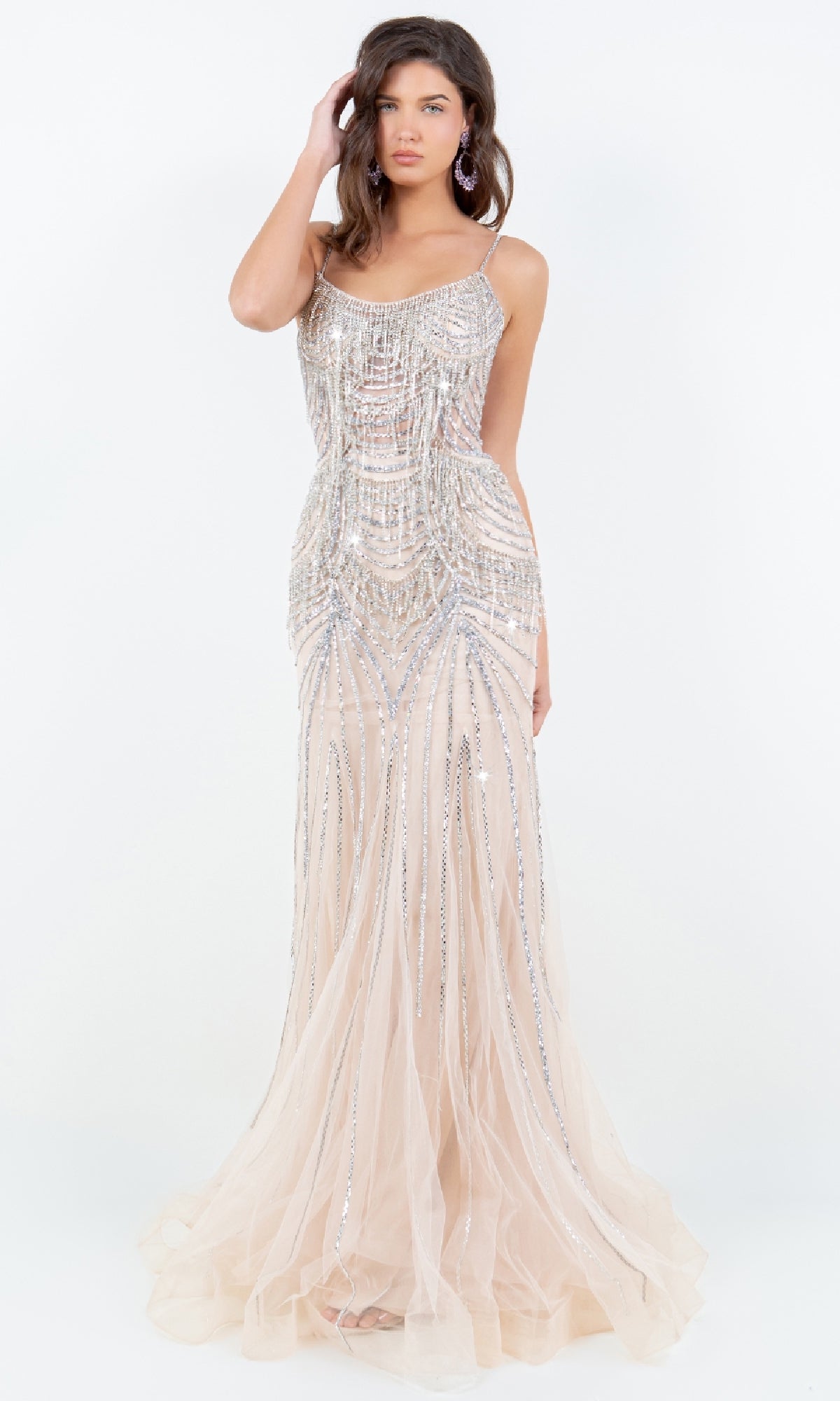 A woman poses gracefully against a white background, wearing the Beaded Long Prom Dress: Cinderella Couture 8192J—a sleeveless, floor-length nude gown with elegant silver beading and lace-up detailing.